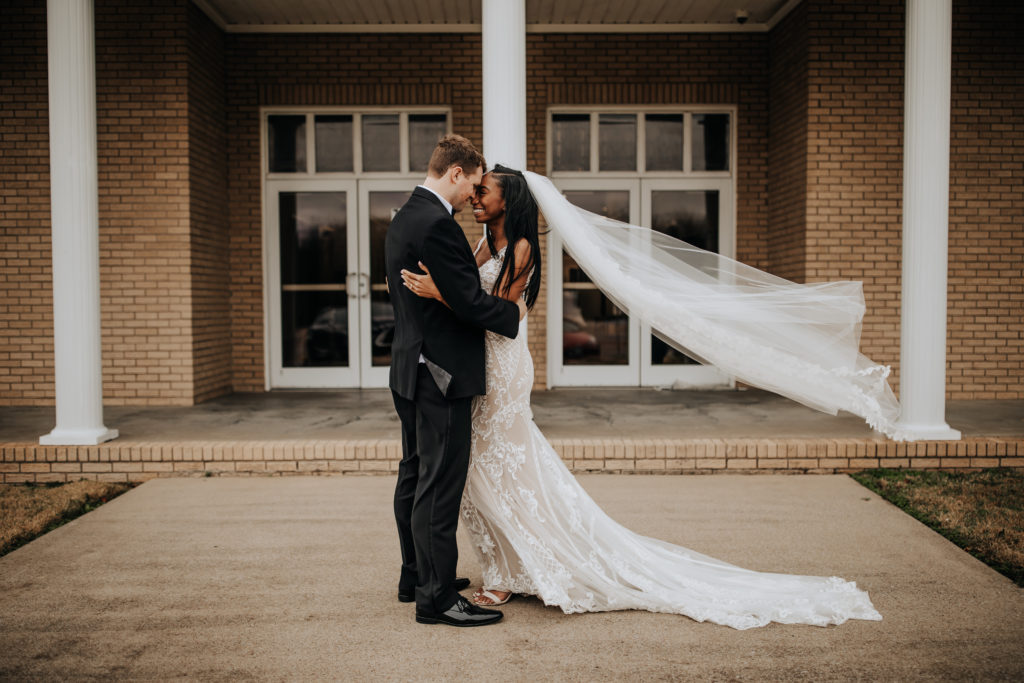 Wedding photo of a couple holding each other with their foreheads touching by Dahlia Orchid Photography a Nashville based wedding and elopement photographer