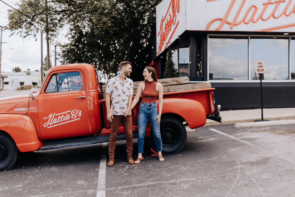 Nashville elopement photographer captures couple holding hands in front of truck at Hattie B's.