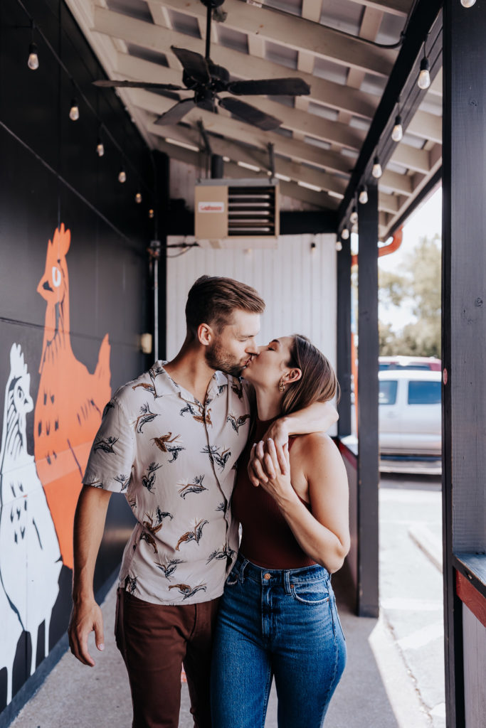 Nashville elopement photographer captures newly engaged couple kissing outside one of Best Eats in Nashville, Hattie B's