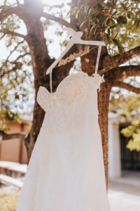 image of a wedding dress hanging from a tree. Nashville Wedding photographer, Nashville country club wedding,