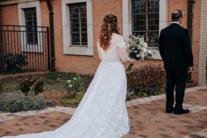 First look image with a bride and her dad. The bride is standing behind her father as he is faced away from her. Nashville wedding photographer. Nashville country club wedding. 
