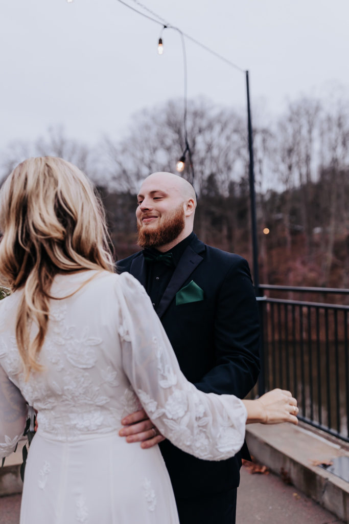 First look image of a groom looking at a bride and crying. Romantic moody Nashville wedding. 