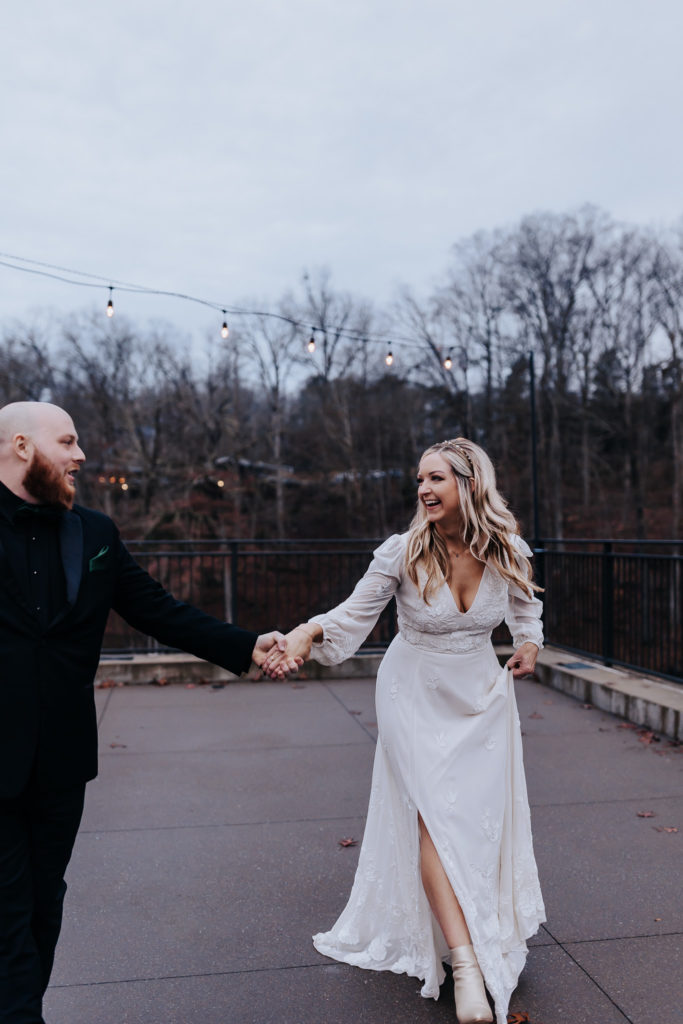 A couple walking towards the camera and smiling at each other. Romantic and moody nashville wedding.