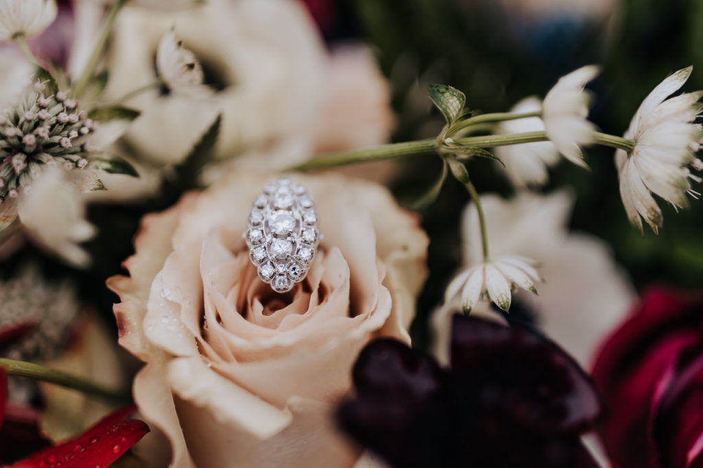 Detail shot of an engagement ring in a bouquet of flowers. Christmas Tree Farm Elopement