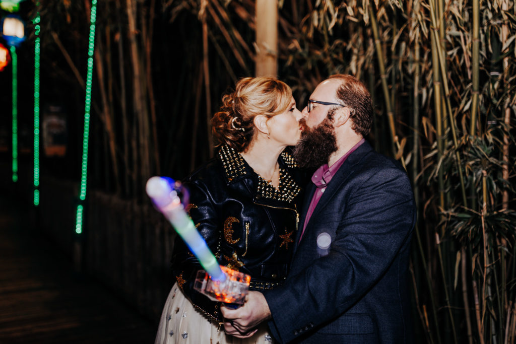 A couple holding a bubble wand smiling at each other on their elopement day. Nashville Zoo Elopement