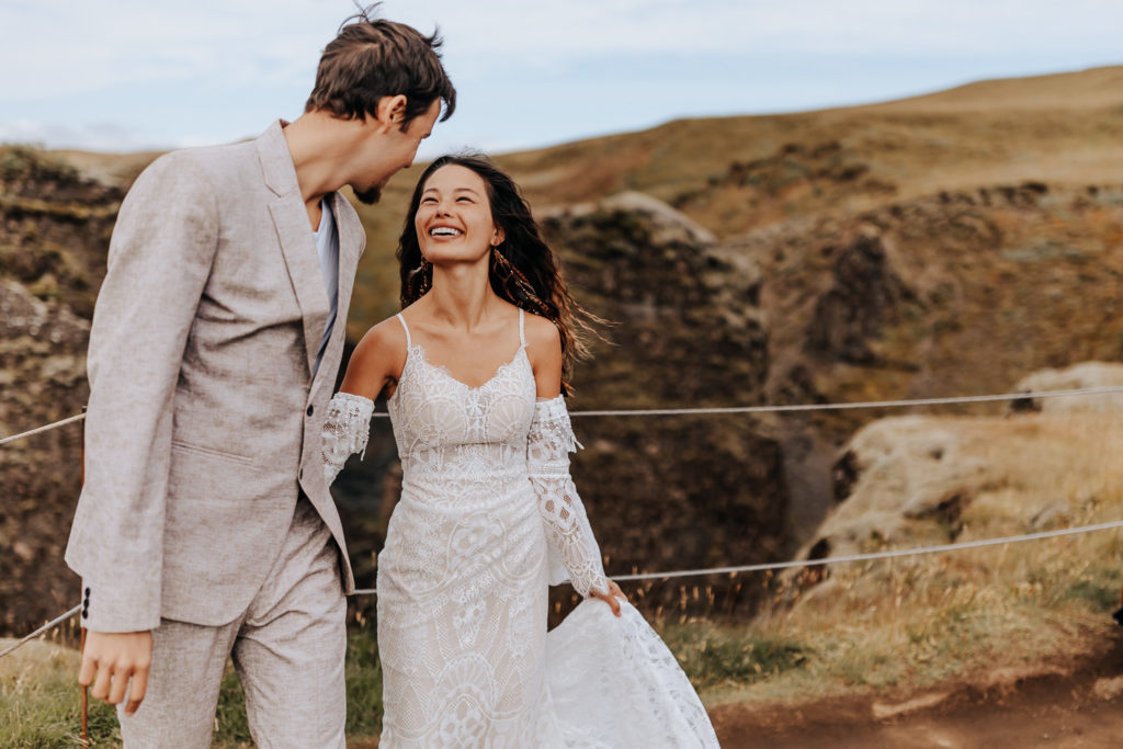 Iceland elopement photographer captures couple walking through mountains during bridal portraits