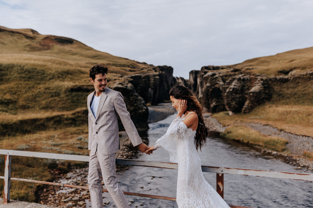 A couple walking along a bridge. Iceland cliff elopement