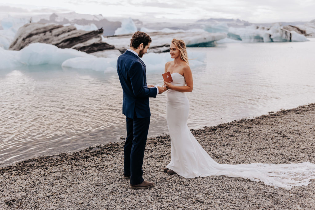 Iceland elopement photographer captures bride and groom reading vows during elopement ceremony