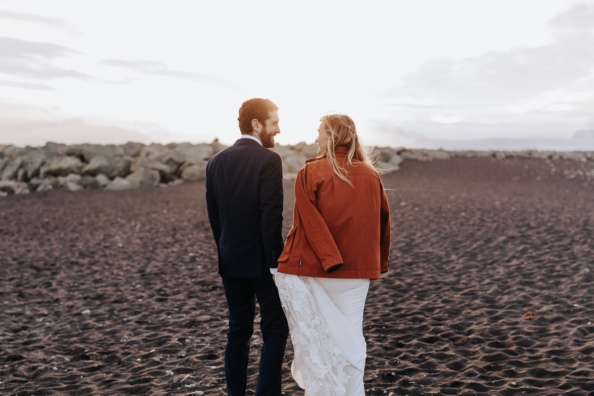 Iceland elopement photographer captures couple walking hand in hand on beach