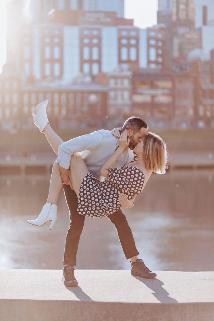 Nashville elopement photographer captures man lifting woman during surprise proposal and engagement session