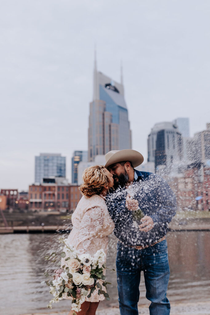 Nashville elopement photographer captures couple celebrating recent marriage with champagne pop in Nashville