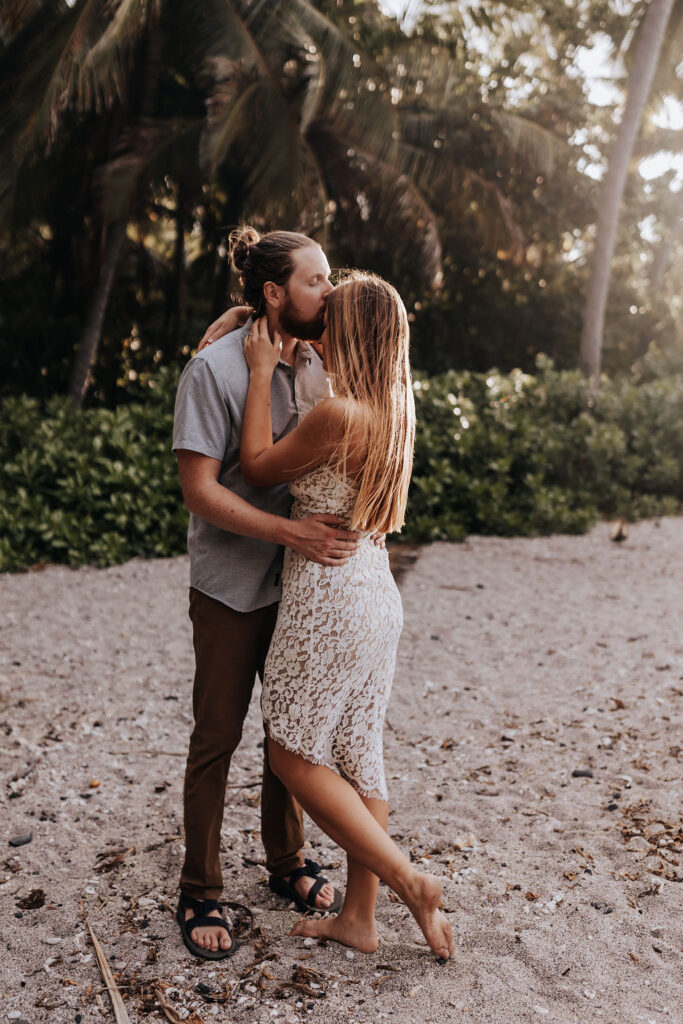Big Island elopement photographer captures couple embracing on the beach after big island honeymoon activities
