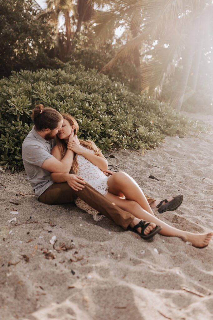Big Island elopement photographer captures couple sitting on the beach after big island elopement