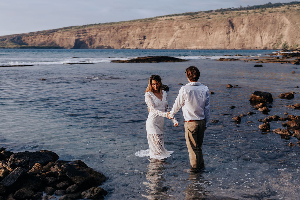 Big Island elopement photographer captures couple walking in ocean before Big Island honeymoon activities