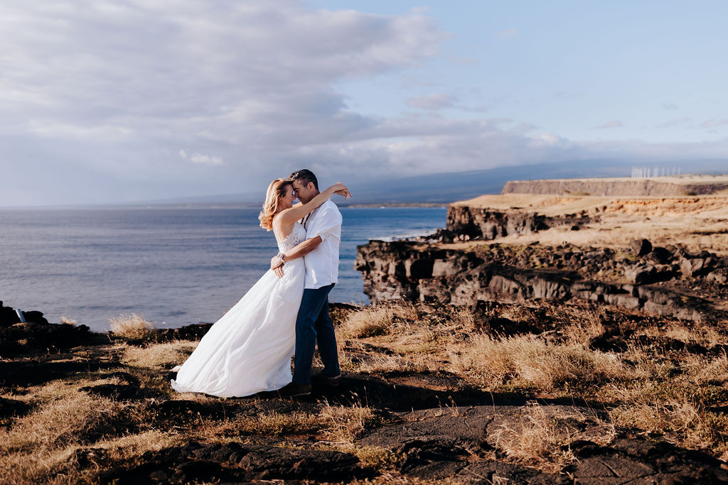 Big Island elopement photographer captures bride and groom standing on cliff after elopement