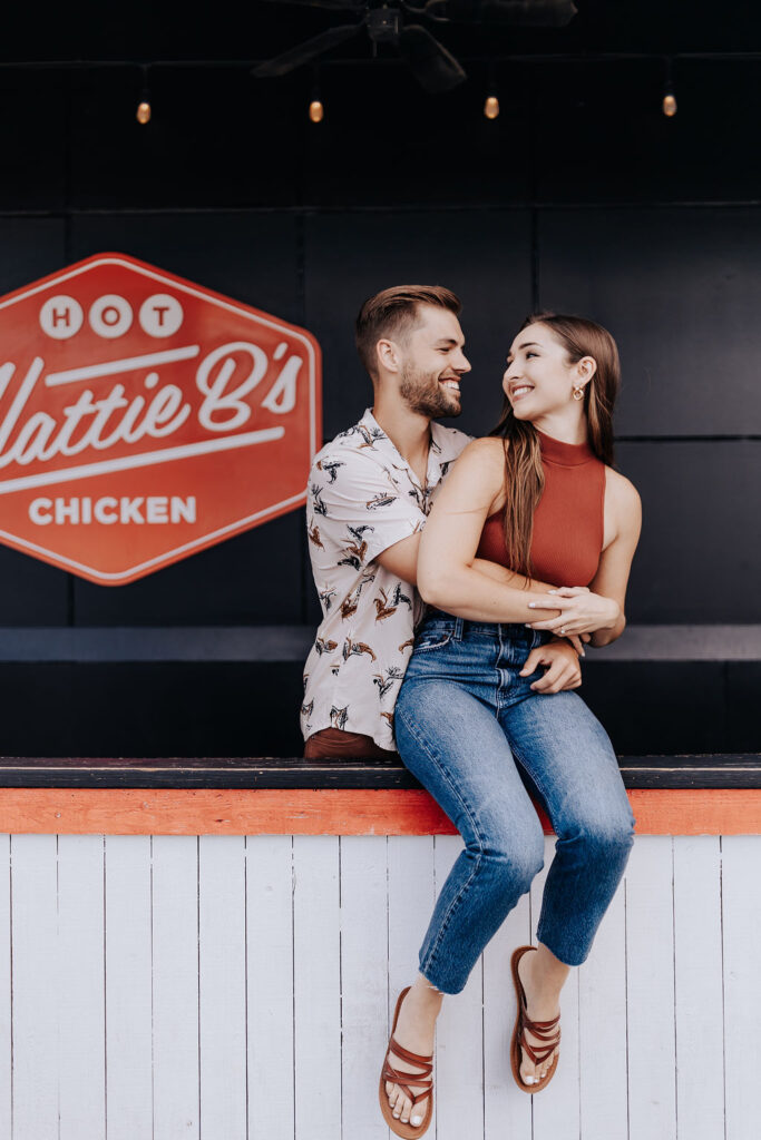 Nashville elopement photographer captures couple sitting on counter at fast food place during unique engagement session