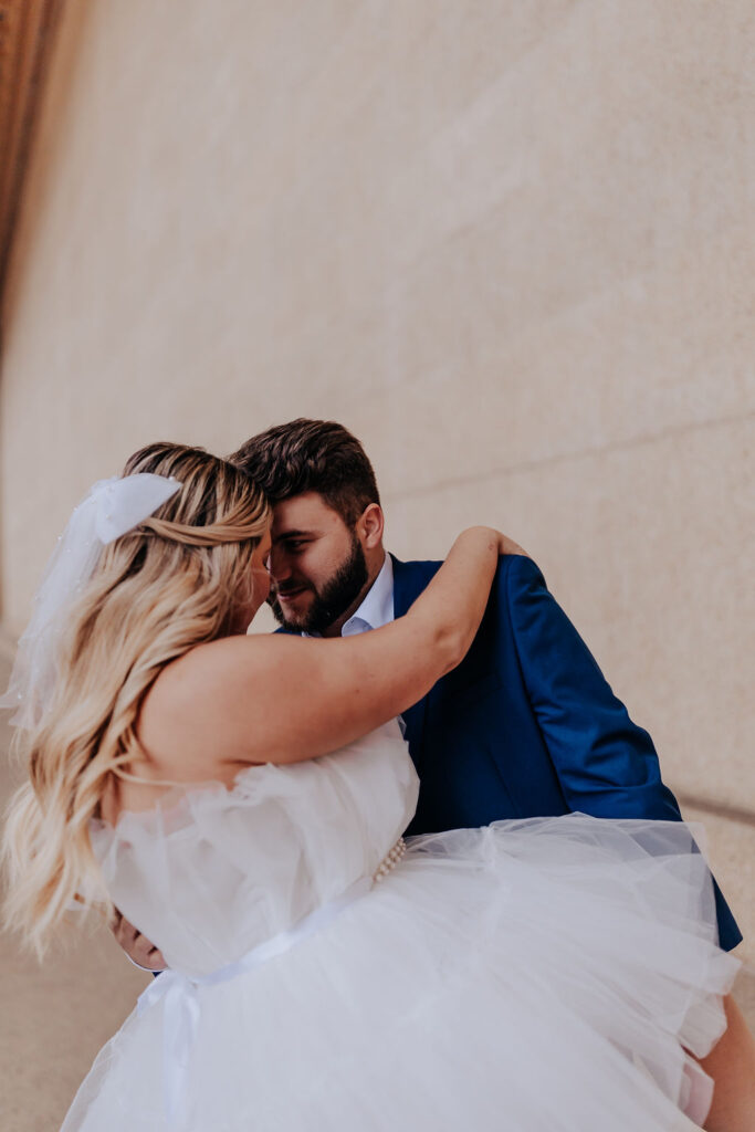 Nashville elopement photographer captures groom holding bride and kissing her softly