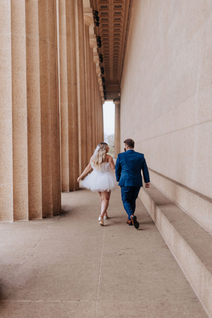 couple walking away from Centennial Park elopement hand in hand