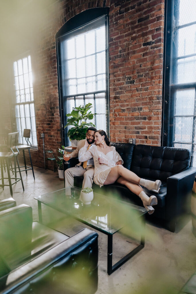 Nashville elopement photographer captures couple sitting on couch together after intimate elopement ceremony for after wedding drinks