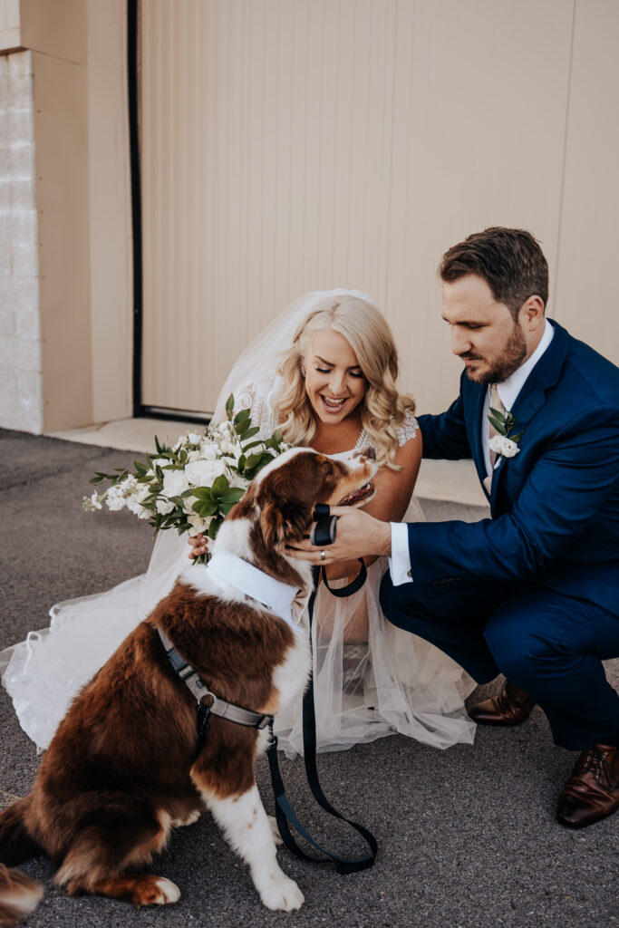 Nashville elopement photographer captures couple in wedding attire hugging dog during bridal portraits