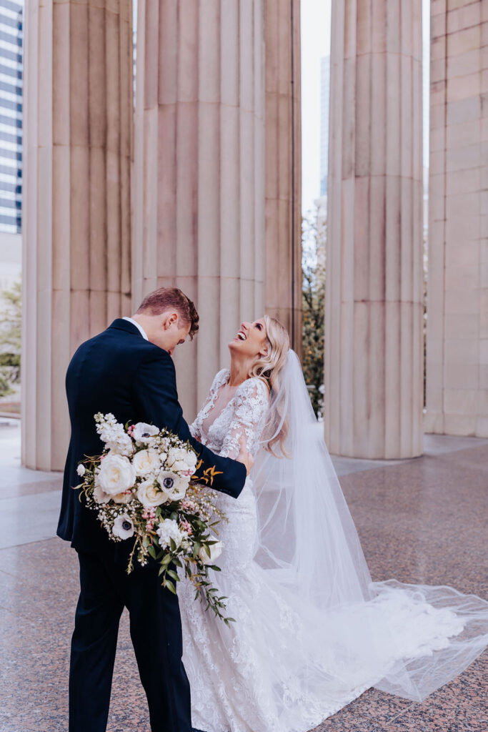 Nashville elopement photographer captures bride laughing during first look before downtown nashville wedding