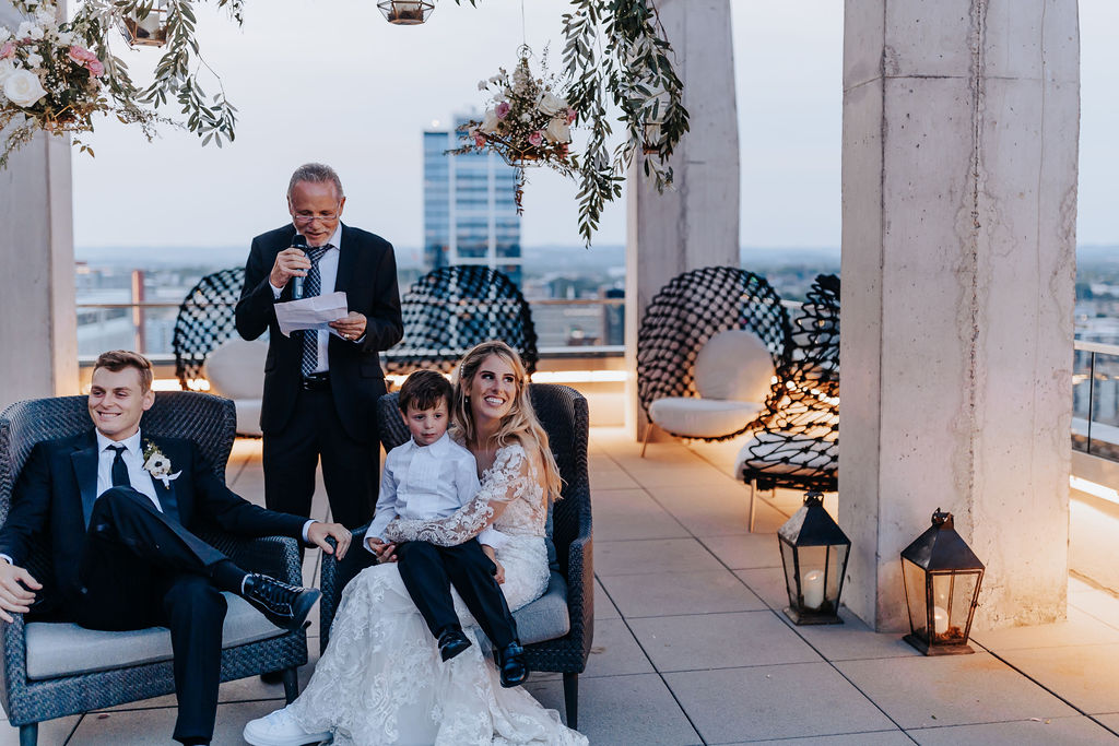 Nashville elopement photographer captures couple sitting while man gives speech at wedding