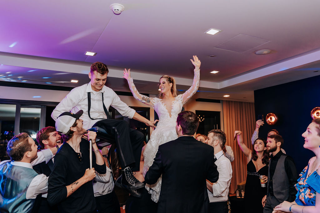 Nashville elopement photographer captures couple being lifted on chairs at wedding reception