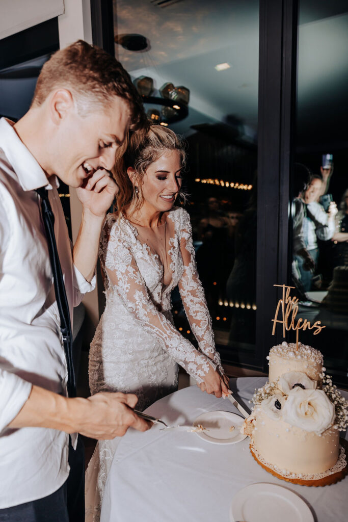 bride and groom cut cake at rooftop wedding reception