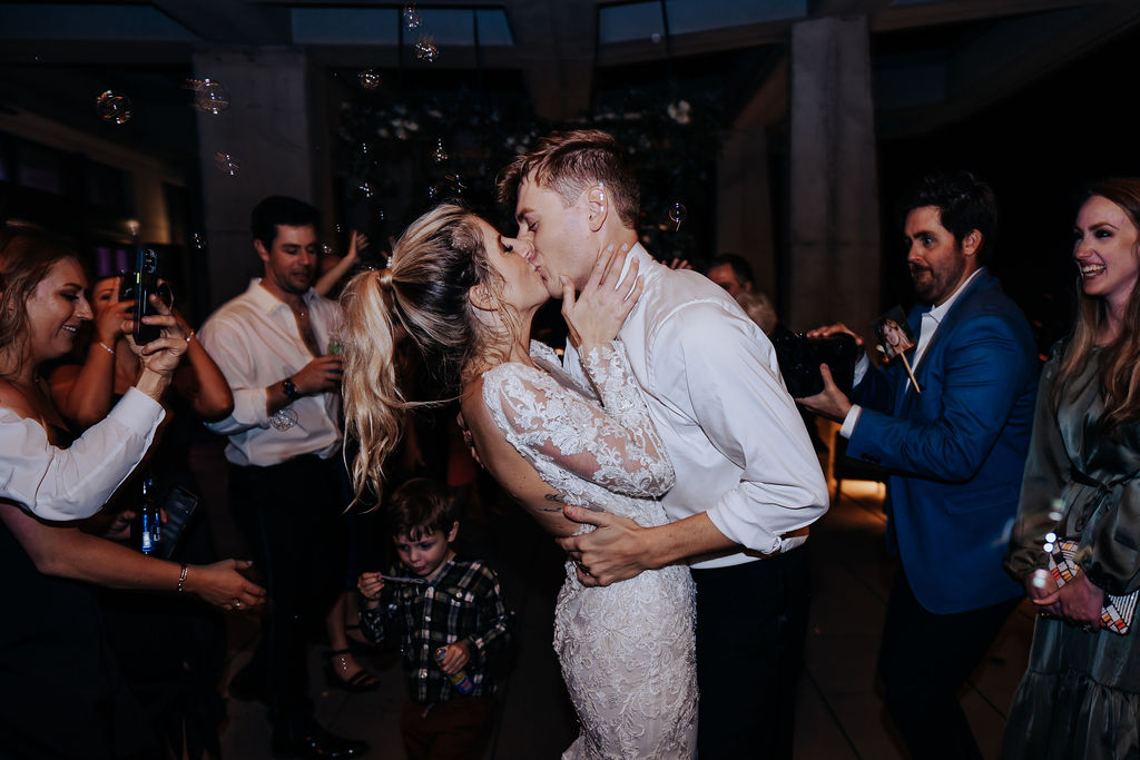 Nashville elopement photographer captures bride and groom kissing after wedding reception ends during bubble exit