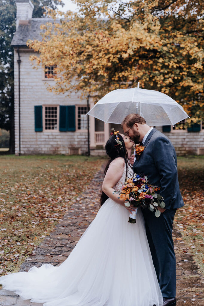 Nashville elopement photographer captures couple kissing under umbrella on rainy wedding day 