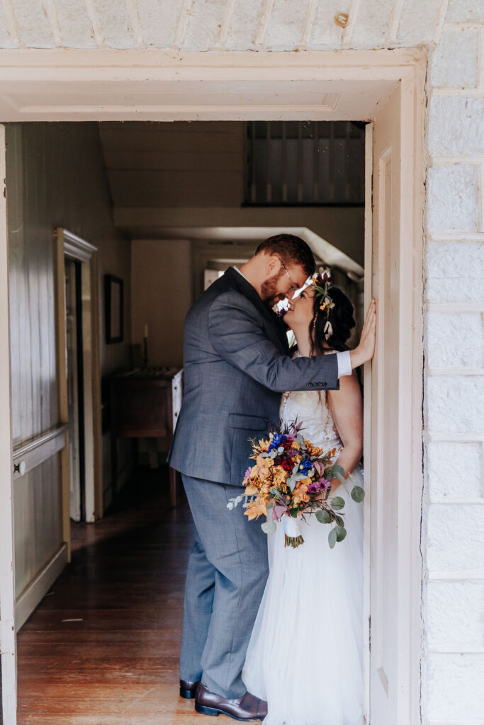 Nashville elopement photographer captures couple kissing against wall during rainy day wedding