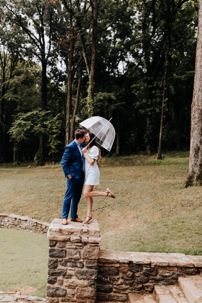 Nashville elopement photographer captures couple standing on column with umbrella