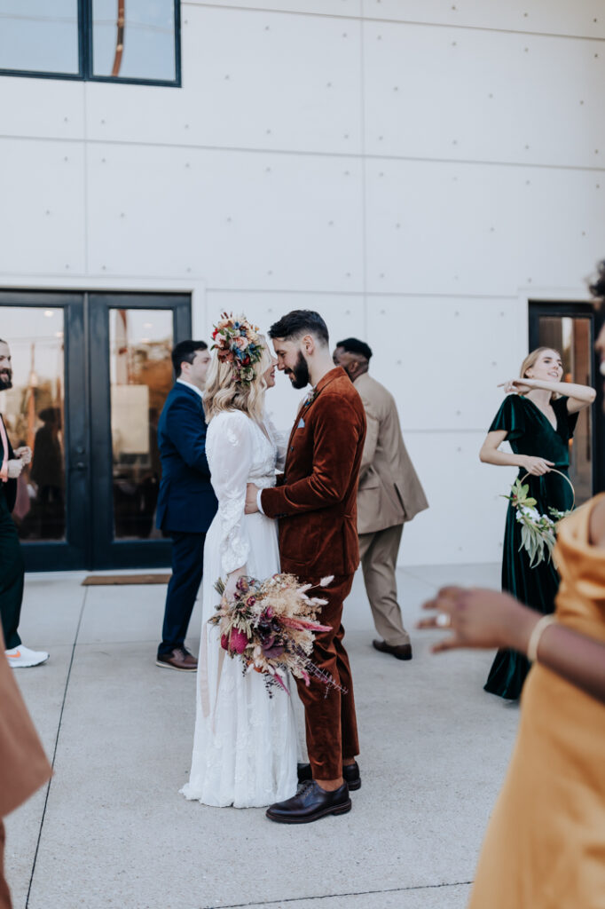 Nashville elopement photographer captures bride and groom embracing while party walks around them