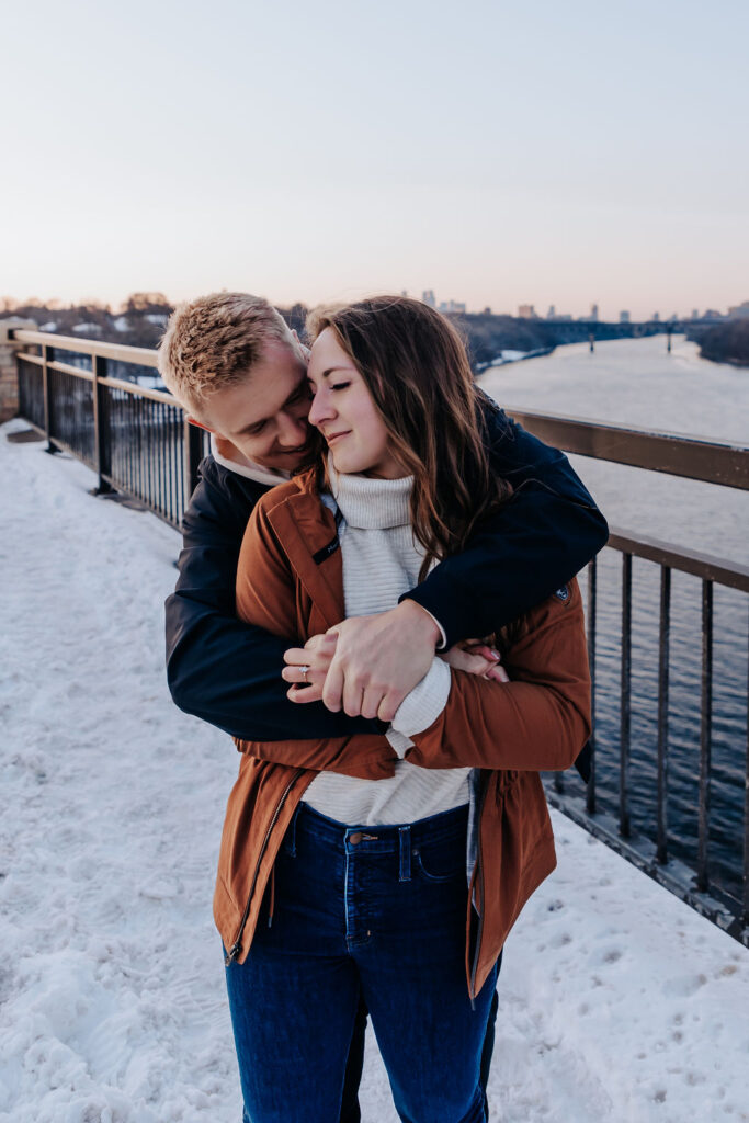 Nashville elopement photographer captures man hugging woman from behind in winter engagement outfits