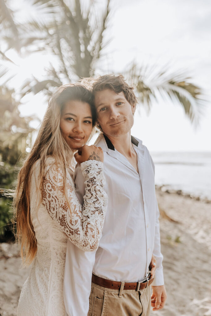 Big Island elopement photographer captures bride and groom in wedding attire smiling together on beach