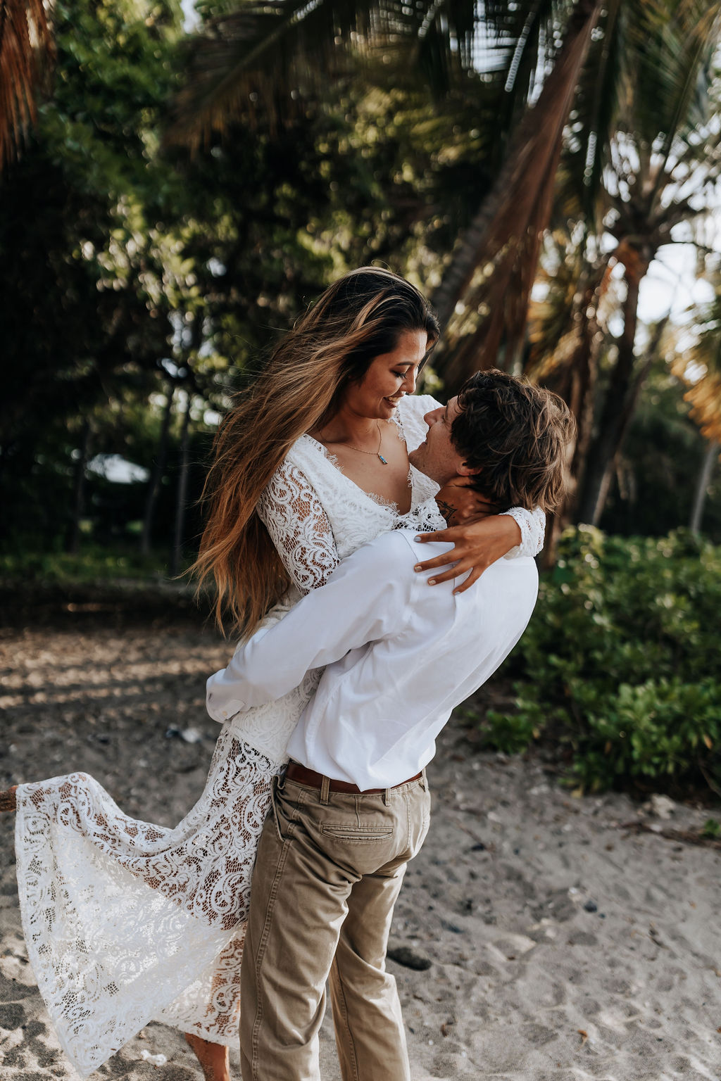 Big Island elopement photographer captures groom lifting bride and spinning her around