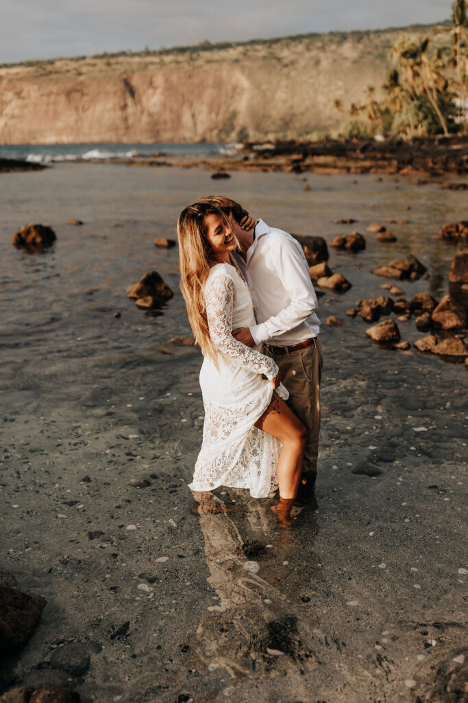 Big Island elopement photographer captures groom kissing bride in water