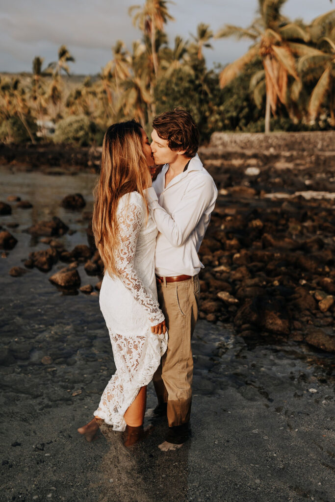 Big Island elopement photographer captures couple kissing in water during bridal portraits