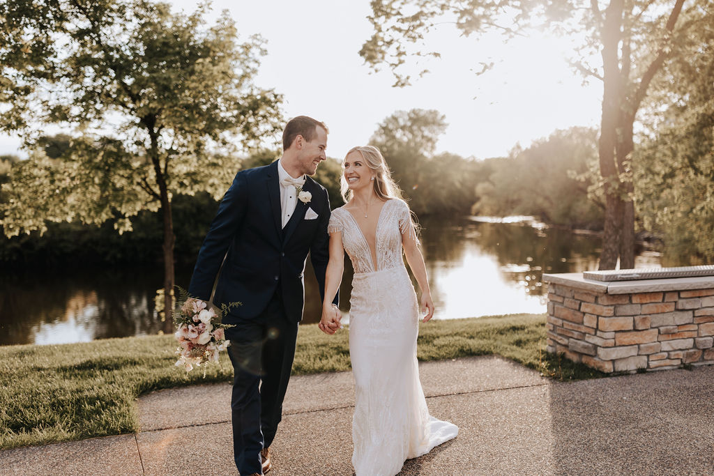 Minneapolis wedding photographer captures bride and groom walking hand in hand at the Jerome Event Center