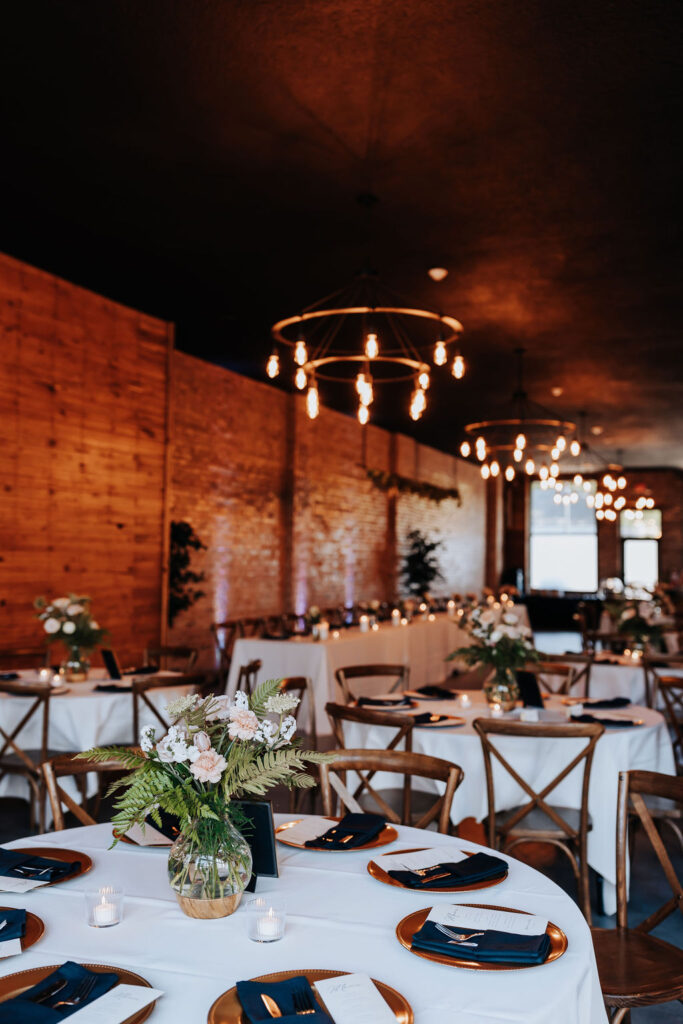 Minneapolis wedding photographer captures indoor wedding reception decor with white tables and elegant decor throughout