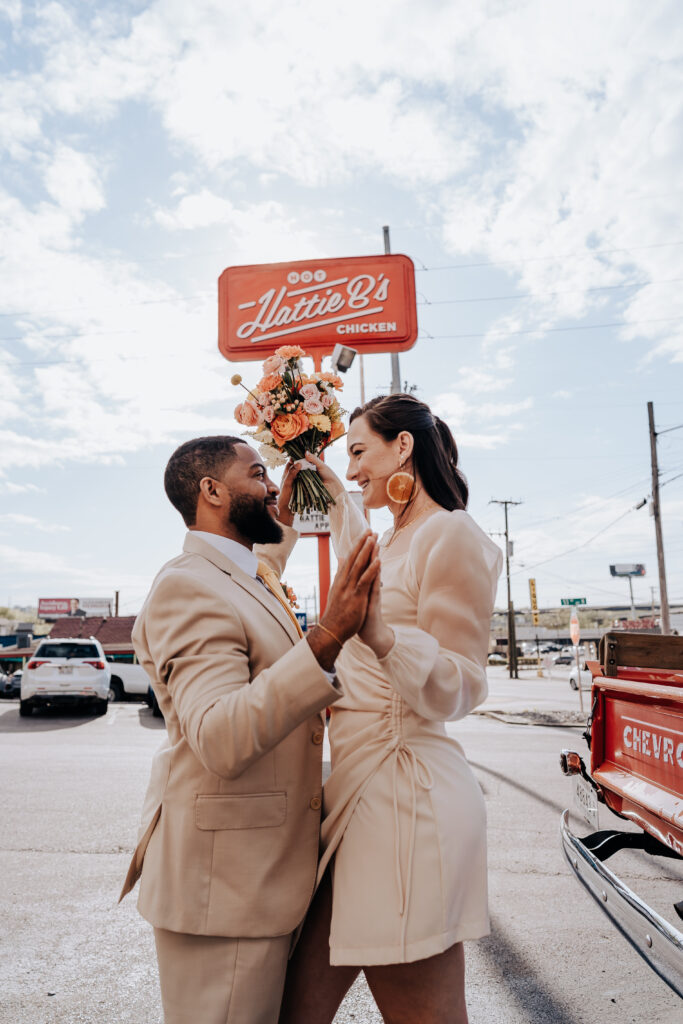 Nashville elopement photographer captures bride and groom hands touching outside of Hattie B's