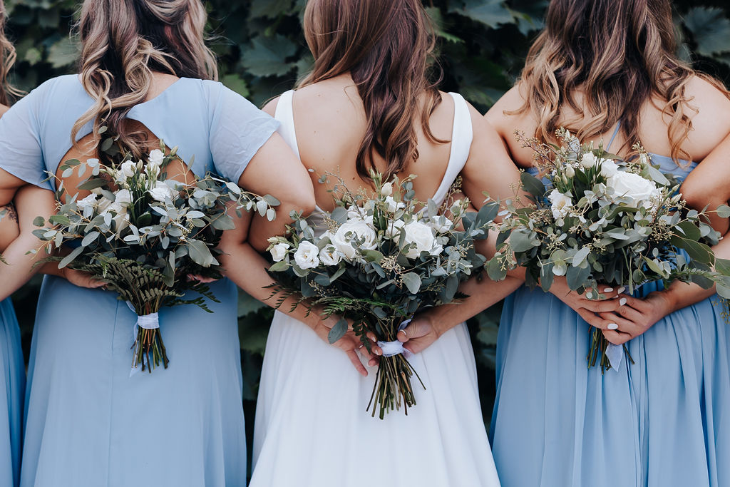 Nashville elopement photographer captures bride holding bouquet behind back with bridesmaids next to her