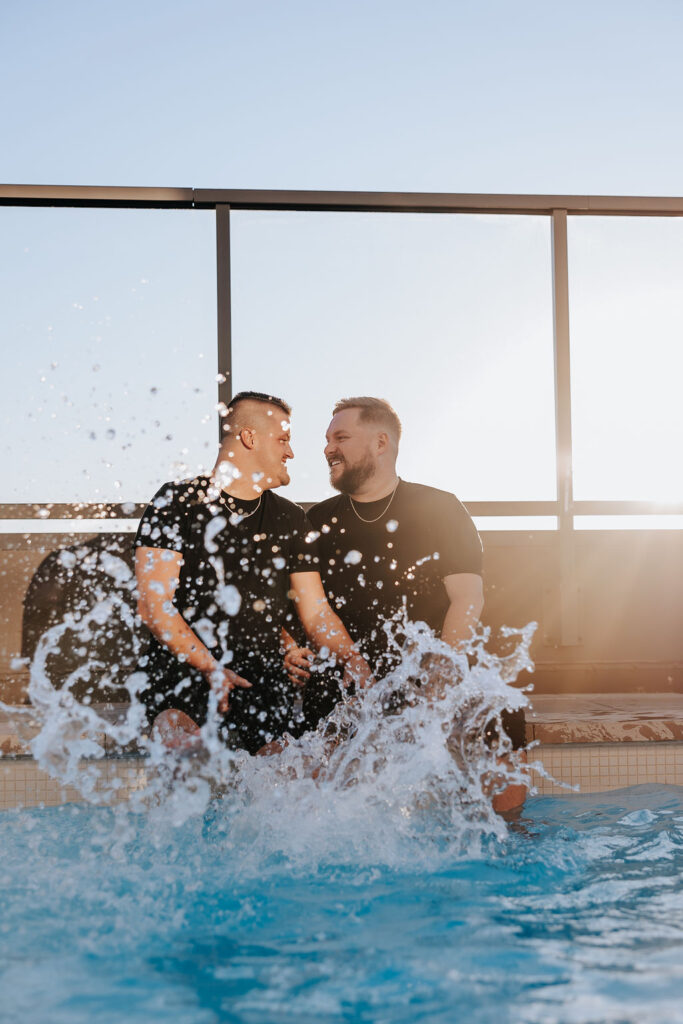 Nashville engagement photographer captures couple sitting in pool splashing