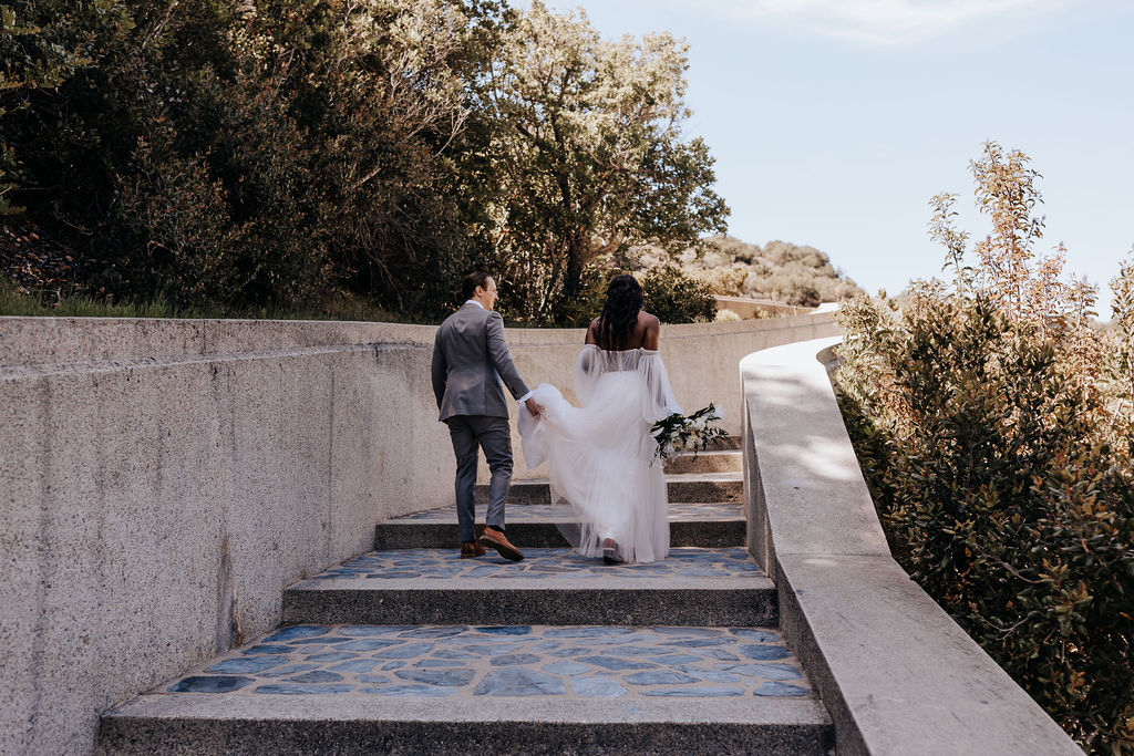 Destination elopement photographer captures bride and groom walking upstairs after romantic Catalina Island elopement