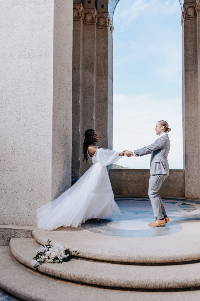 Destination elopement photographer captures bride and groom holding hands and smiling together 