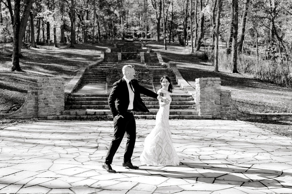 Nashville elopement r photographer captures bride and groom holding hands and walking in black and white portrait