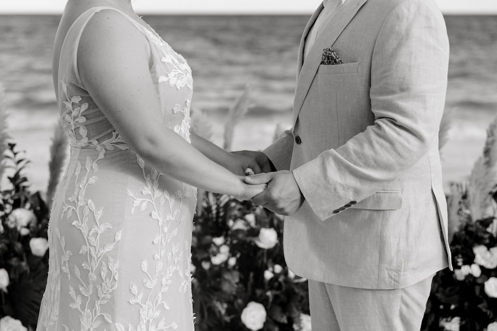 Destination wedding photographer captures bride and groom holding hands during destination resort wedding ceremony