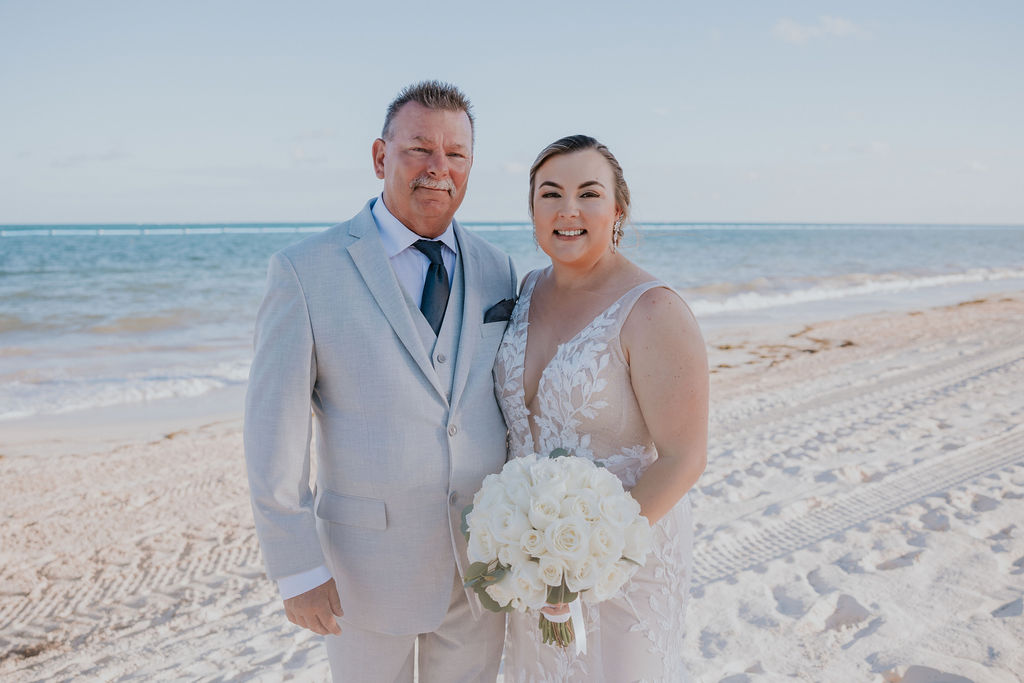 Destination wedding photographer captures bride with father during formal portraits on beach
