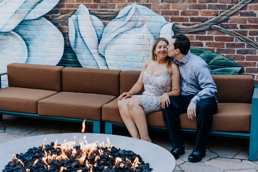 Nashville elopement photographer captures newly engaged couple sitting on couch kissing during engagement photos
