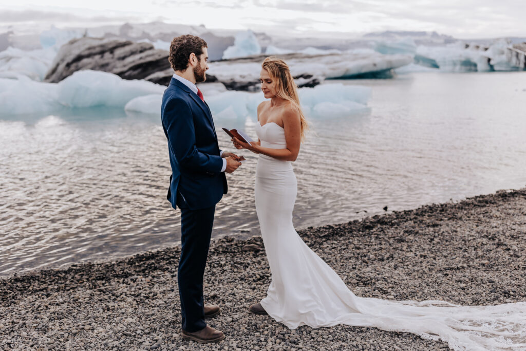 Destination wedding photographer captures bride and groom reading vows during Iceland wedding